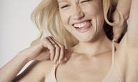 A woman smiling at the camera and wearing a Calida top from the 'Eco Sense' range.