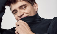 Uomo in abbigliamento lounge basic di CALIDA, sorride rilassato alla telecamera, tirando il dolcevita del top leggermente sopra il mento.