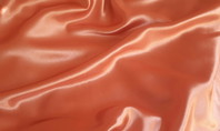Gros plan sur un tissu en polyester de couleur orange, brillant avec des plis doux.