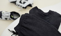CALIDA RMX LOUNGE TIME OFF sweatshirt lying on a white couch. White sneakers can be seen in the background.