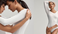 Deux femmes en bodys blancs simples. La moitié gauche de l'image montre les deux femmes dans une étreinte intime, tandis que la moitié droite montre l'une des femmes posant avec assurance, une main derrière la tête.