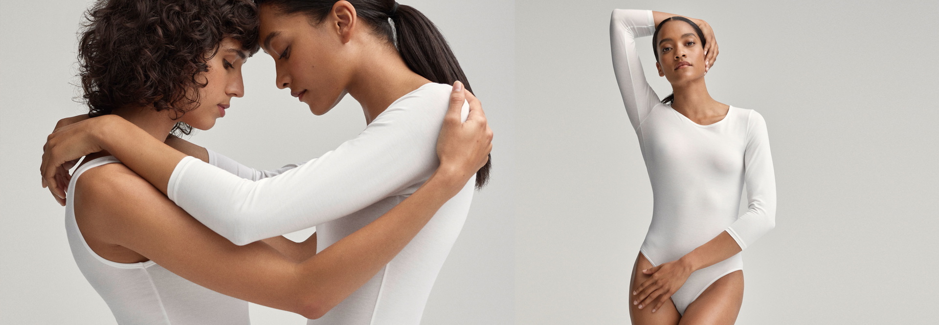 Deux femmes s'enlacent tête contre tête sur le côté gauche, tandis qu'une femme sur le côté droit passe son bras autour de sa tête. Toutes portent un body blanc de CALIDA.