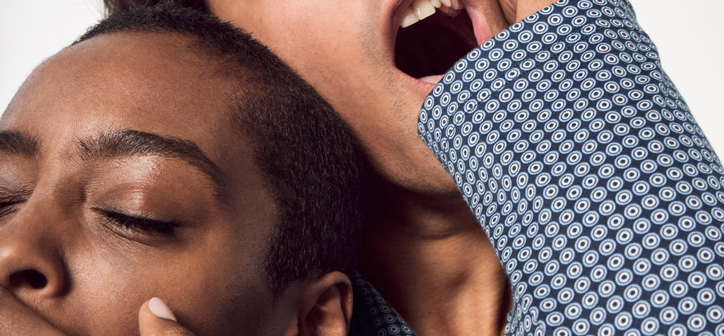 Auf dem Bild sind ein Mann und eine Frau in engem Beisammensein zu sehen, beide gähnen müde. Der Mann lehnt seinen Kopf auf den der Frau, während sie Schlafanzüge von CALIDA tragen. Die Szene vermittelt eine vertraute und gemütliche Atmosphäre häuslicher Verbundenheit.