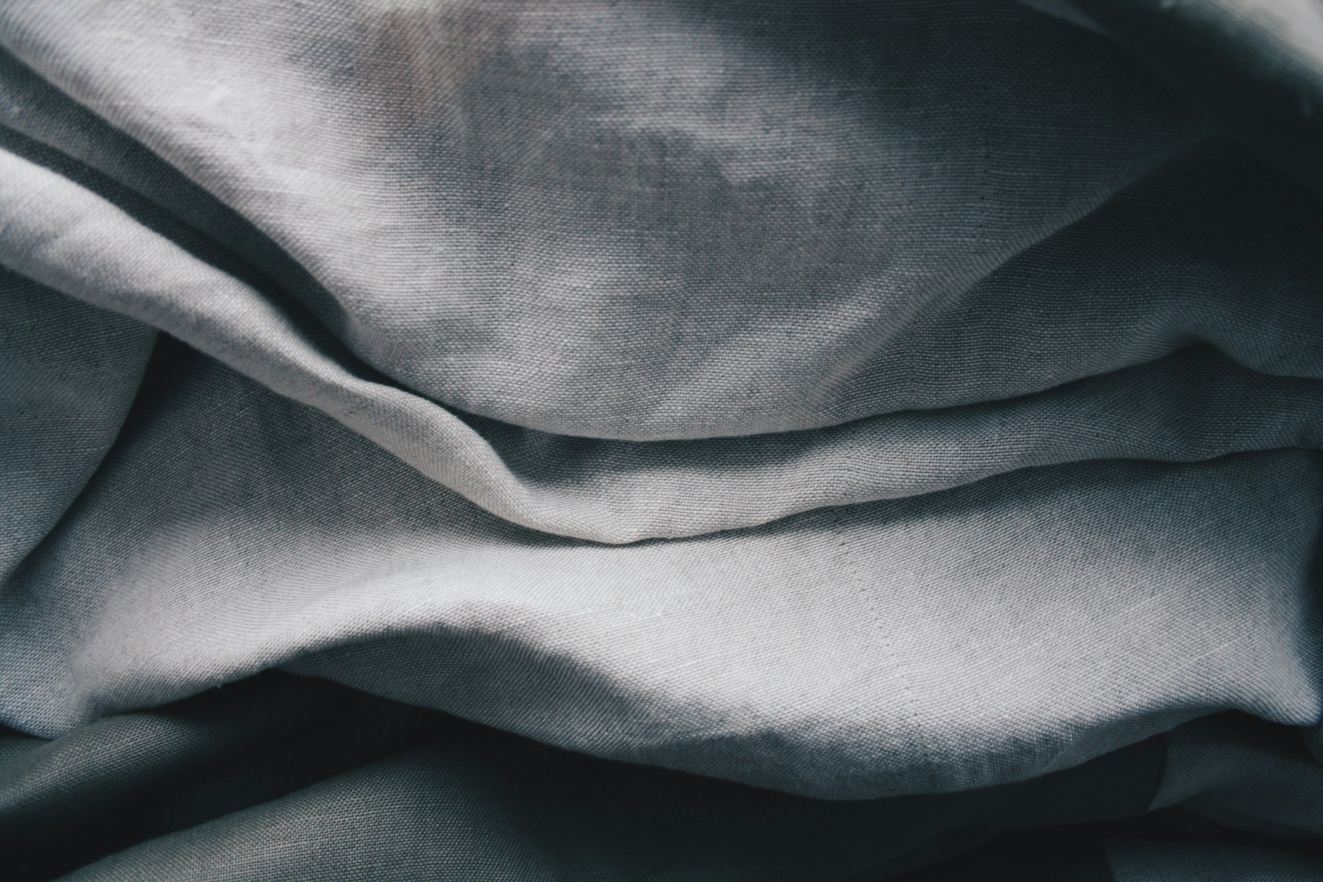Close-up of folded linen fabric in various shades of grey.
