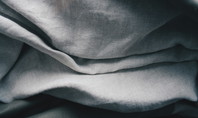 Close-up of folded linen fabric in various shades of grey.