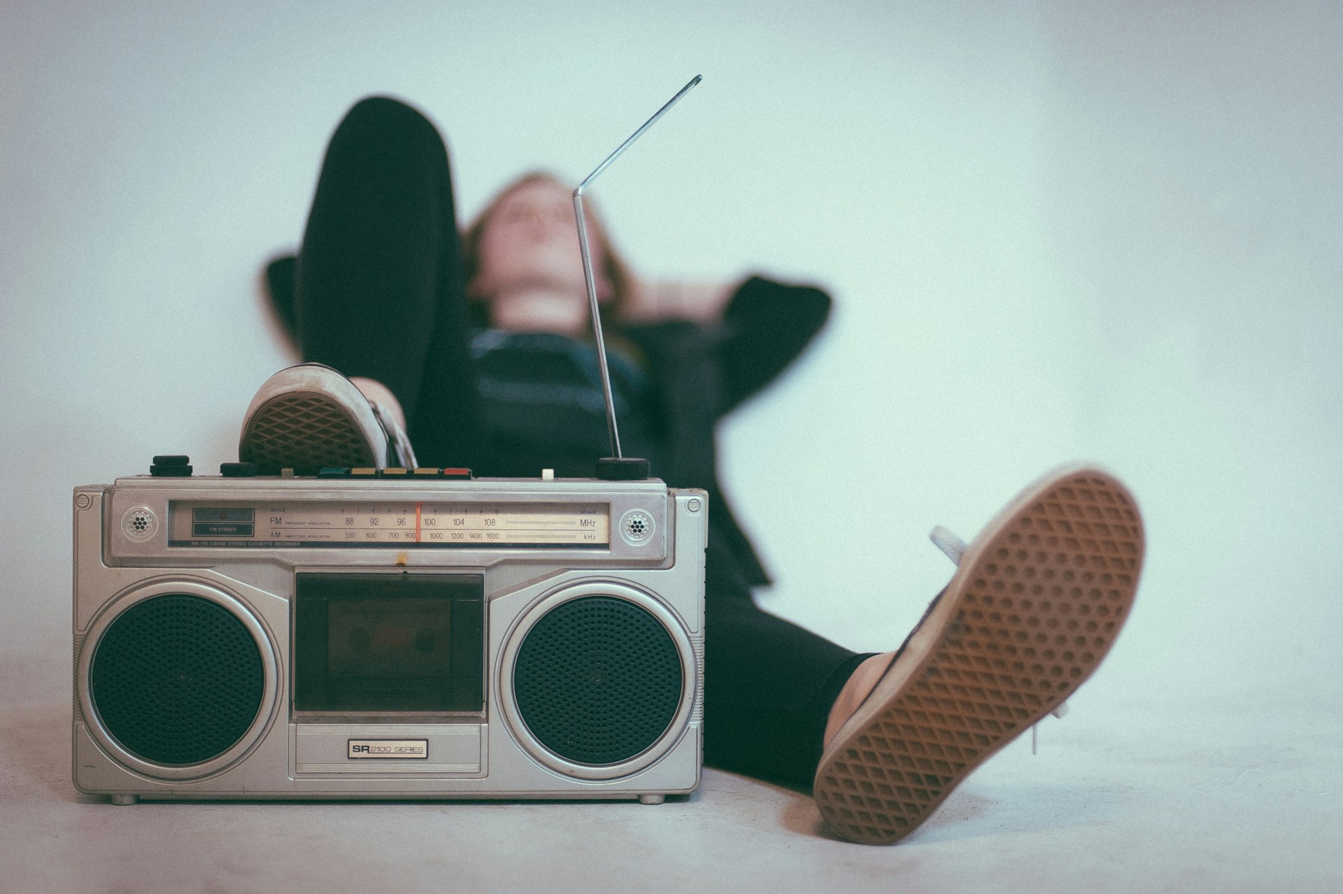 Une personne se détend avec un radiorécepteur rétro et les jambes étendues.