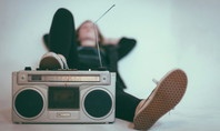 Une personne se détend avec un radiorécepteur rétro et les jambes étendues.