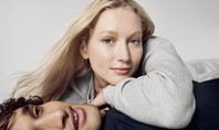 Un couple décontracté en vêtements CALIDA, présentant le Zwiebellook. La femme porte un pull gris, l'homme un haut foncé, tous deux ont l'air sereins et stylés.