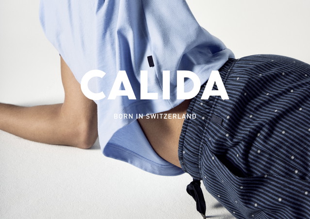 Image publicitaire de CALIDA : personne en vêtement de nuit bleu, allongée sur un fond clair, avec le logo et le slogan 'Born in Switzerland' visibles.