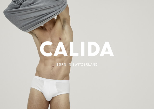 Un homme en caleçon blanc enlève son t-shirt. Inscription CALIDA avec le sous-titre 'Born in Switzerland'.