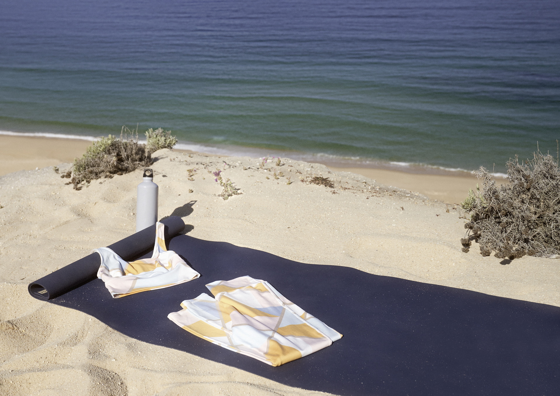 Tapis de yoga avec vêtements de yoga CALIDA sur la plage