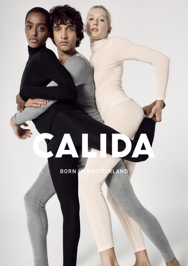Trois mannequins en tenues Calida moulantes à manches longues en noir, gris et beige posent enlacés sur un fond clair. Inscription 'CALIDA - Born in Switzerland'.