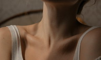Gros plan sur une zone du cou et des épaules, symbolisant les douleurs cervicales après le sommeil.