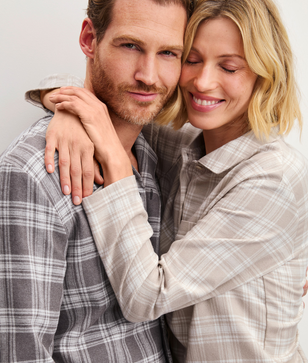 Die Dame und der Herr tragen karierte Flanell Pyjamas.