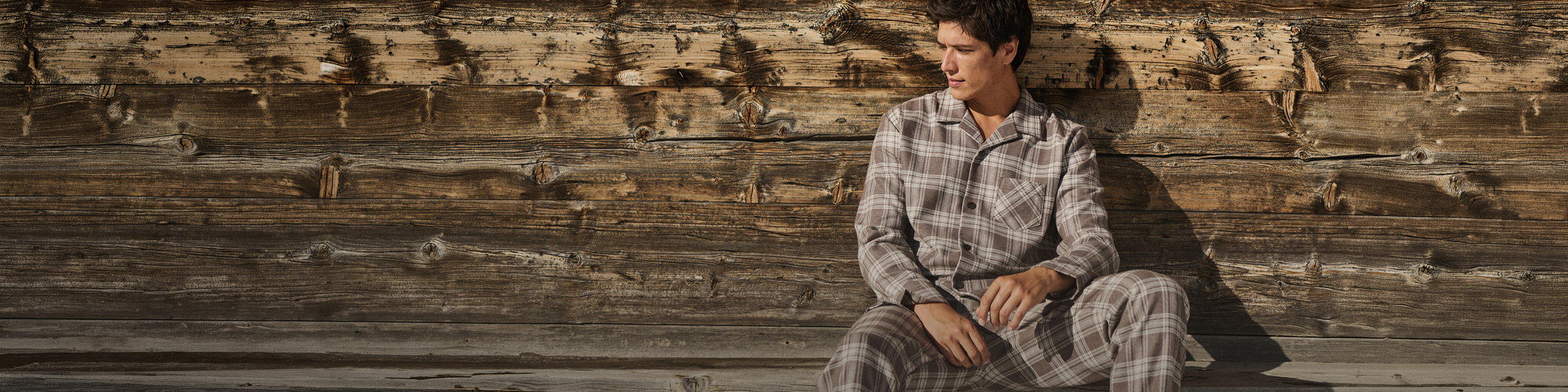 Gentleman in a brown checked flannel pajama in an autumnal setting.