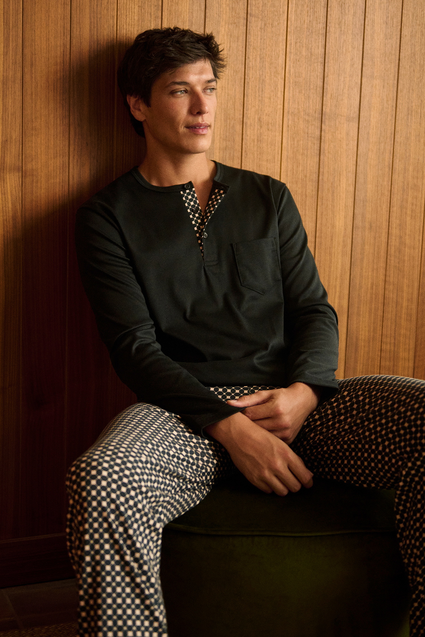Pyjamas with sun print: A person is wearing dark pyjamas with a striking sun pattern in shades of yellow in a close-up.