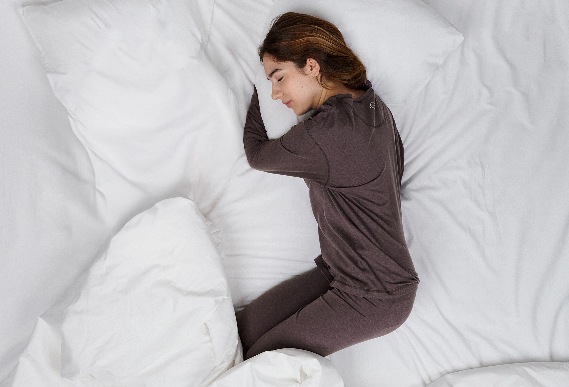 The lady is wearing pyjamas from the DEEPSLEEPWEAR Warming range in a soft brown colour.