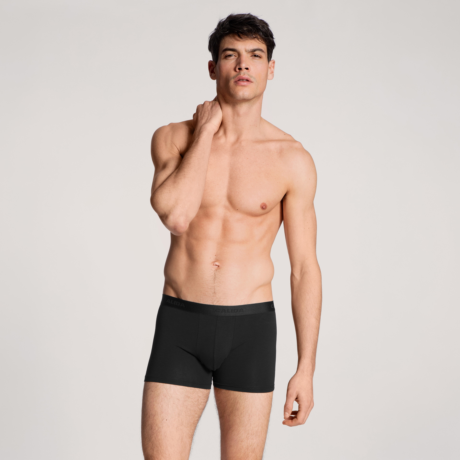 Le mannequin porte un boxer bleu de la série Natural Benefit et un pull bleu foncé de la série Circular Lounge.  