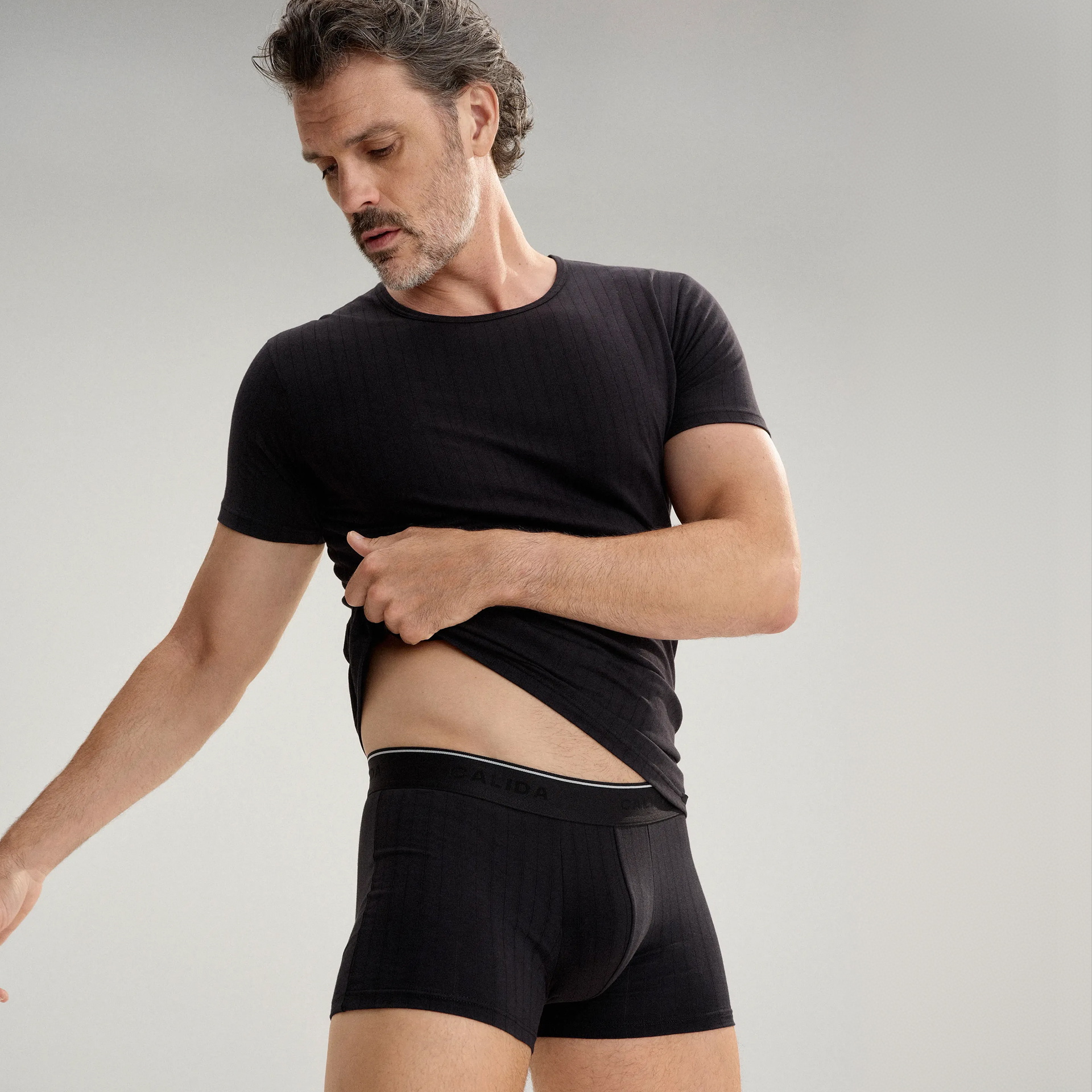 Le mannequin porte un t-shirt blanc et un boxer blanc de la série Pure & Style de la marque CALIDA.