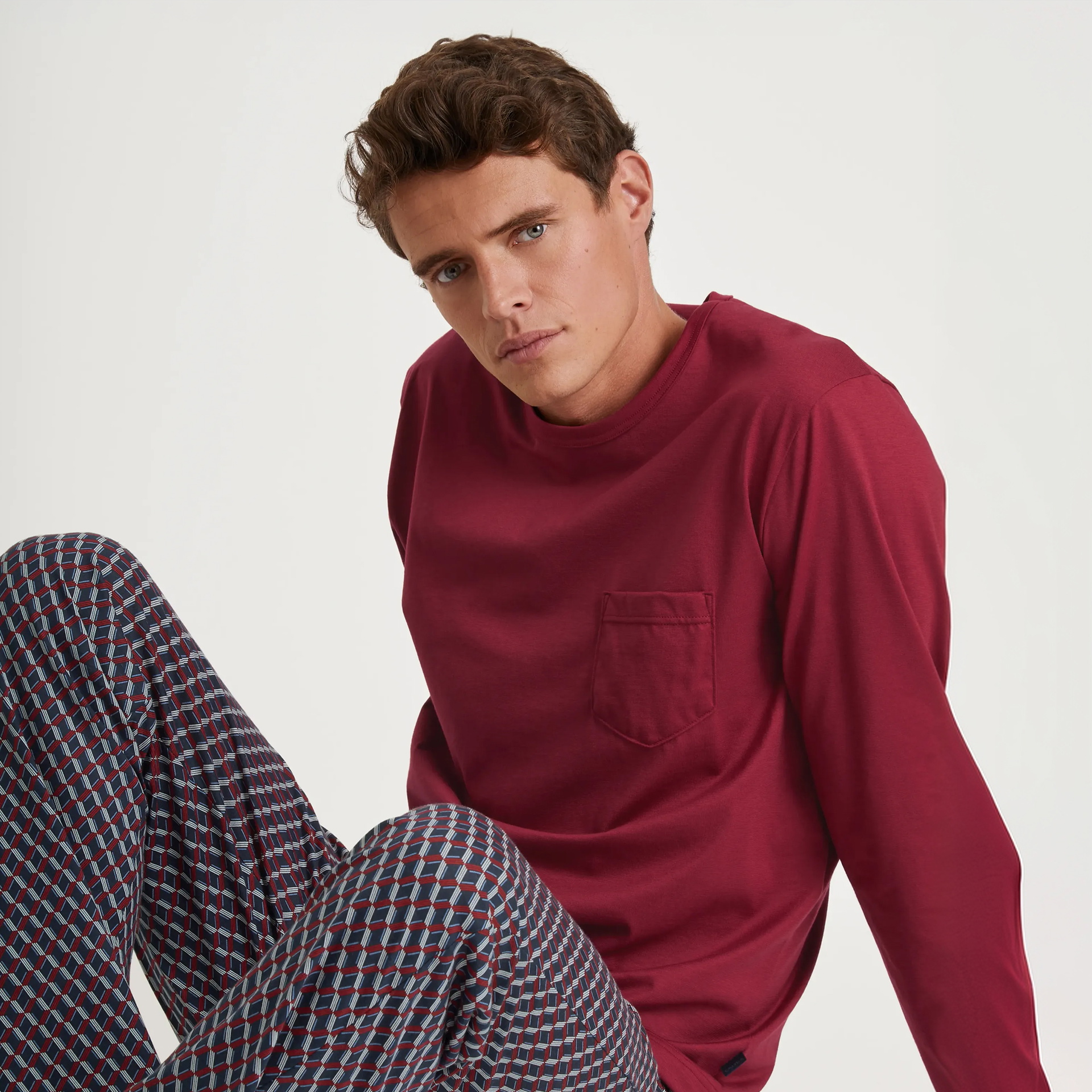 Le mannequin porte un pyjama rouge de la marque CALIDA, issu de la série Relax Imprint. 