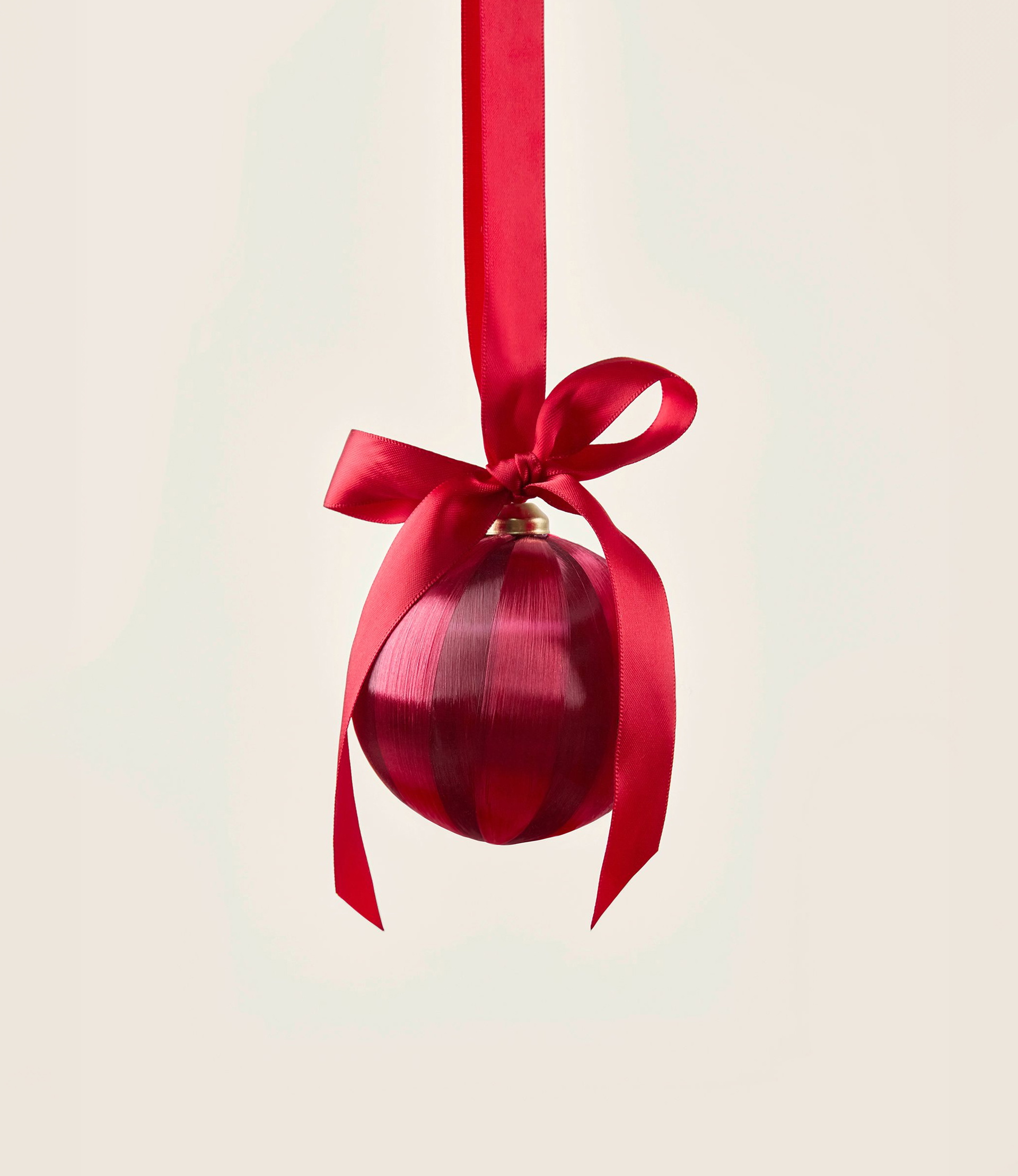 Boule de Noël festive en rouge avec un nœud décoratif comme accessoire atmosphérique pour la saison des cadeaux.