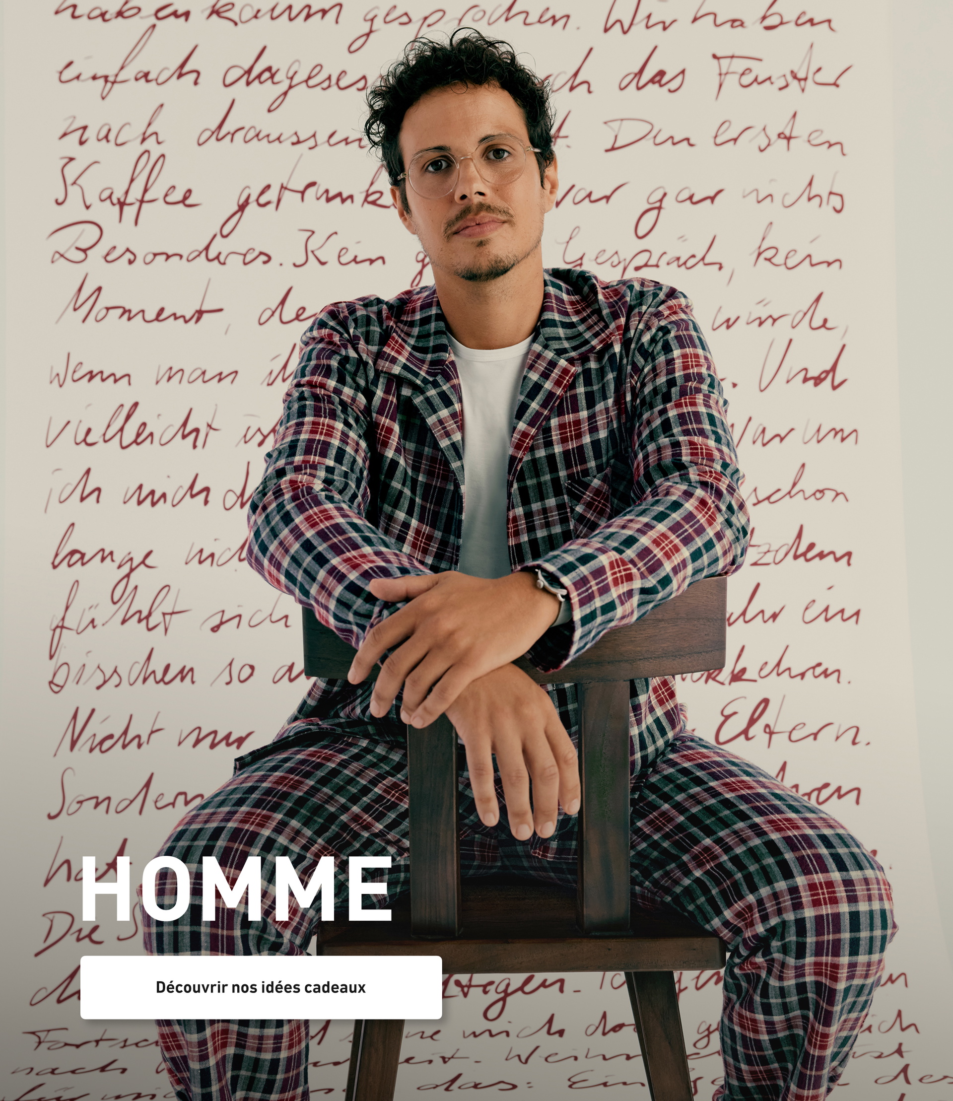 Le modèle porte un pyjama en flanelle à carreaux dans les tons bleu et bordeaux et présente un look d'hiver classique pour des nuits détendues.