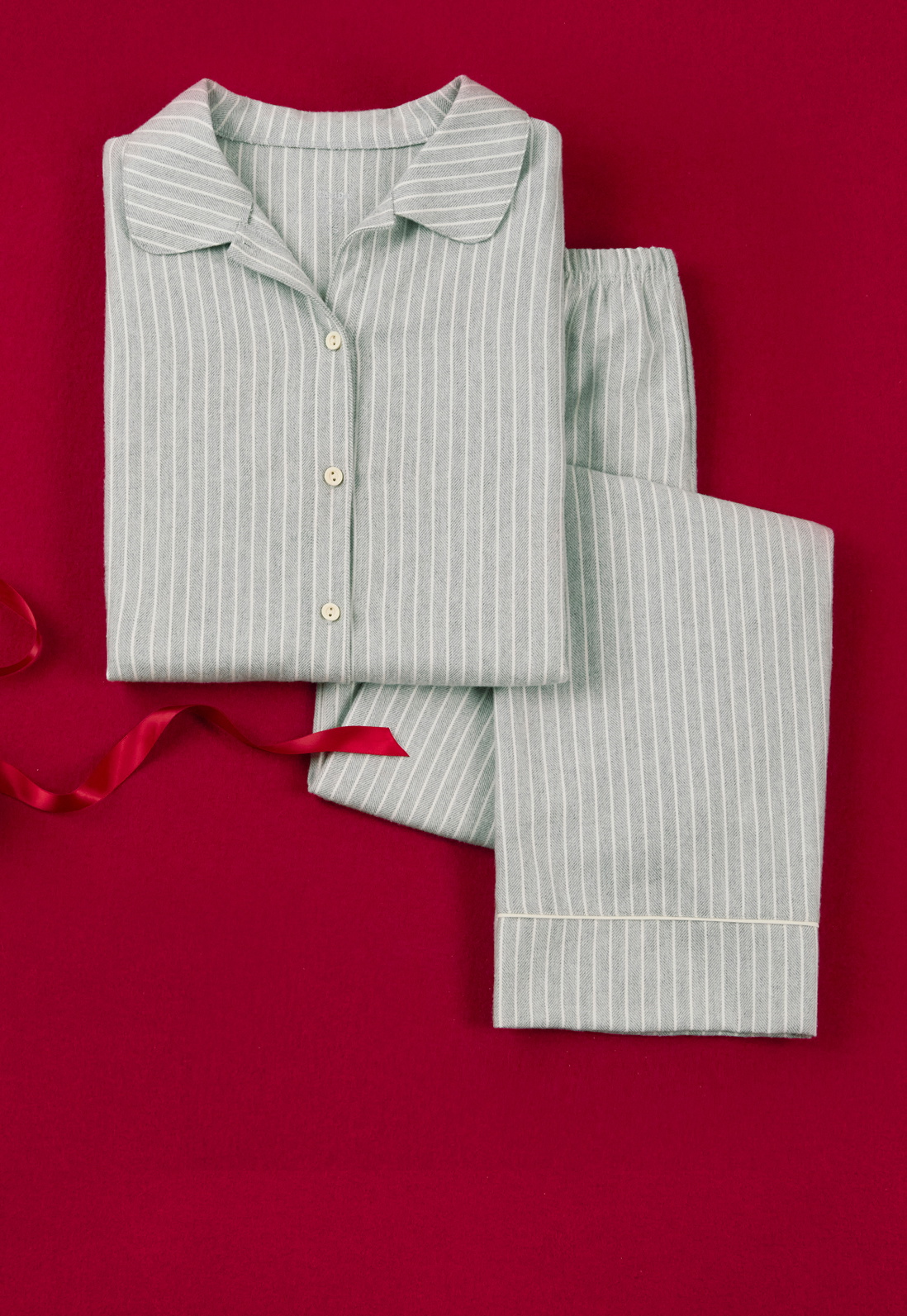 Pyjama classique à fines rayures bleu clair, présenté comme une idée cadeau élégante pour des nuits détendues.