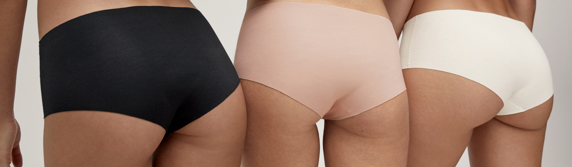 Back view of three women wearing seamless CALIDA Natural Skin underwear with clean-cut edges in nude shades. 